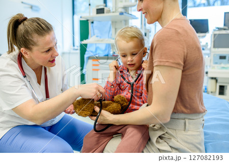 Little boy trying pediatrician's stethoscope during medical examination. 127082193