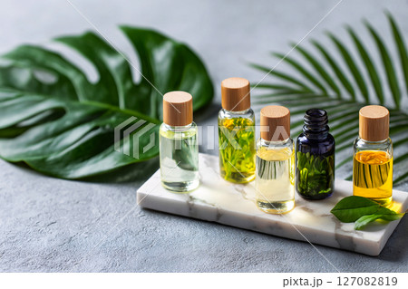 aromatherapy oils on marble with tropical leaves, wellness spa concept, mood relaxation 127082819