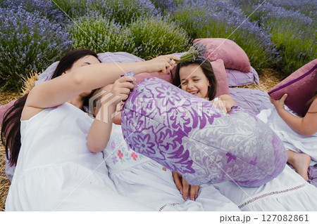 At the center of the shot is a bed where a young mother and her three daughters rest in the middle of the lavender field 127082861