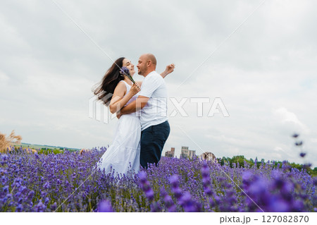 A young couple in love stands listening to the silence of the lavender field and the beating of their hearts 127082870
