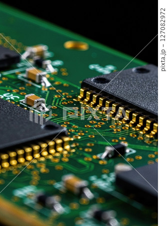 High Resolution Macro Close Up of Modern Microchip on Green Printed Circuit Board with Gold Connectors and Electronic Components for Technology Concepts 127082972