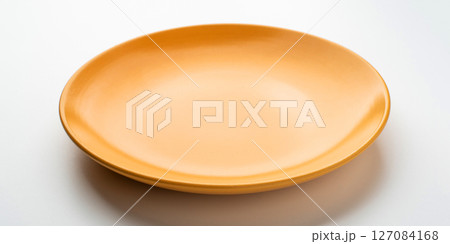 Yellow ceramic plate on a white table. 127084168