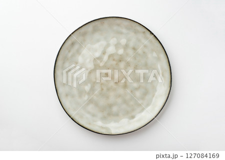Empty textured plate on white background Empty textured plate on white background 127084169