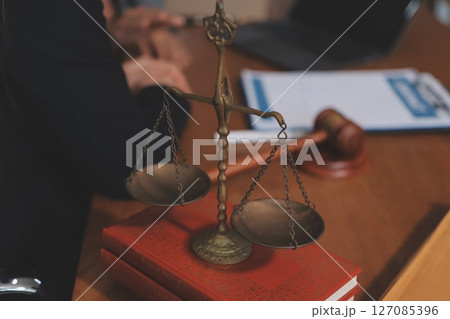 Judge gavel with Justice lawyers having team meeting at law firm background. Concepts of Law and Legal services. 127085396