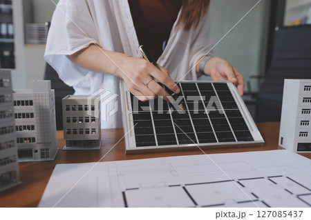 Discussion among businesspeople on the latest developments in solar cell panel technology and Solar Energy Environment city Concept. 127085437