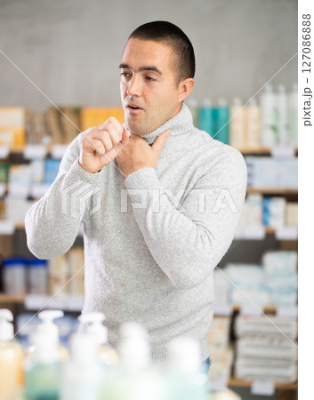 Man pharmacy client suffers from sore throat and cold Man pharmacy client suffers from sore throat and cold 127086888