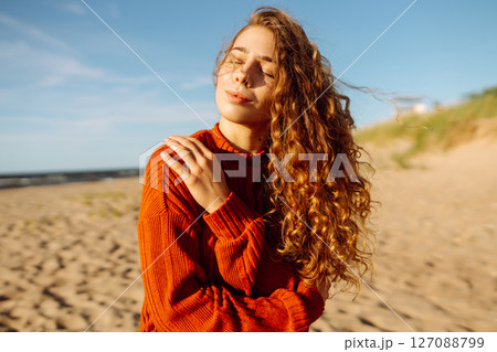 Outdoor portrait of pretty woman on the beach in cold sunny weather. Travel, fashion, blogging Outdoor portrait of pretty woman on the beach in cold sunny weather. Travel, fashion, blogging 127088799