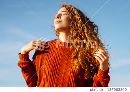 Outdoor portrait of pretty woman on the beach in cold sunny weather. Travel, fashion, blogging 127088800