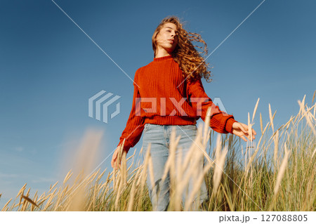 Beauty woman enjoying nature outdoors in grass. Calmness and tranquility. Travel, tourism concept. 127088805