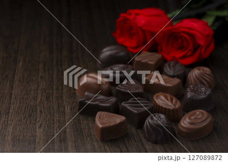 木目テーブルに並ぶ高級チョコレートのアソートと薔薇 木目テーブルに並ぶ高級チョコレートのアソートと薔薇 127089872