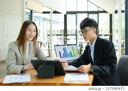 Two business people discuss financial strategy and collaborate with colleagues. 127090451