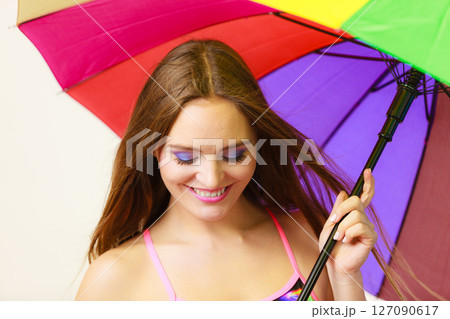 Woman standing under colorful rainbow umbrella 127090617