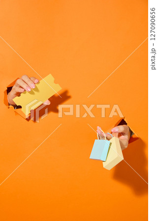 Cutout illustration of hands exchanging coupons and cash, suggesting a lively market exchange or promotional transaction moment. 127090656