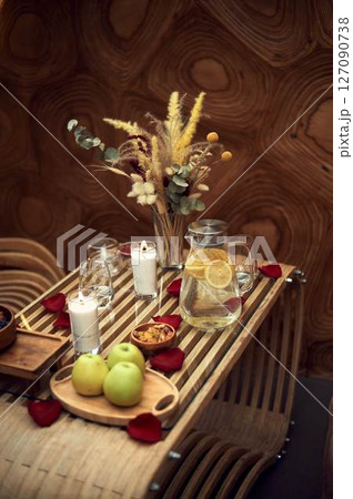 Romantic dinner in the spa area. Candles, a jug of water and lemon and fruit. An atmosphere of relaxation 127090738