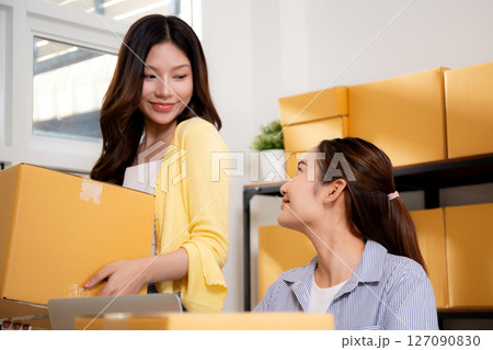 Two young asian businesswoman checking order of customer for laptop computer and document. Two young asian businesswoman checking order of customer for laptop computer and document. 127090830