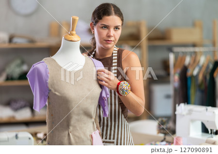 Female fashion designer working with mannequin and sewing fabric Female fashion designer working with mannequin and sewing fabric 127090891
