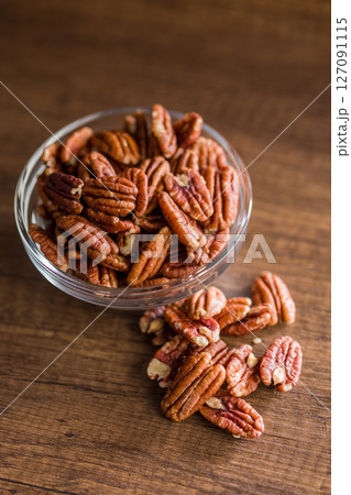 Peeled pecan nuts in bowl on wooden table. 127091115