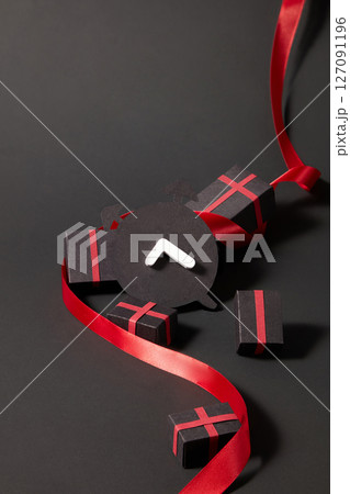 The paper clock is surrounded by scrolls and boxes, stylized to convey discount codes or offers by letter in an abstract, graphic shopping theme. 127091196