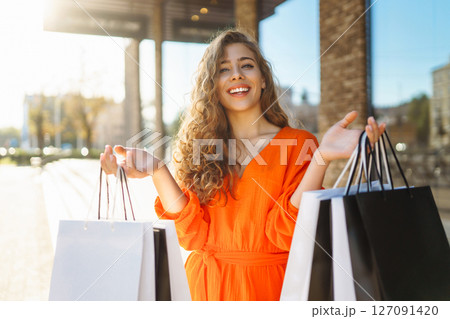 Young woman with shopping bags near mall. Purchases, shopping, lifestyle, sale concept. Young woman with shopping bags near mall. Purchases, shopping, lifestyle, sale concept. 127091420