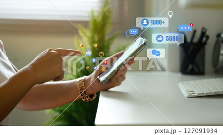 Finger touching mobile screen with visual floating social media icons symbolizing online influence 127091934