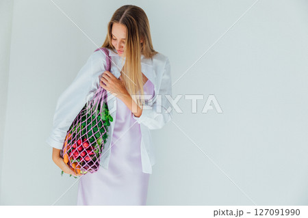 woman holding a bag of vegetables for diet food and smiling woman holding a bag of vegetables for diet food and smiling 127091990
