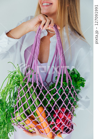 woman holding a bag of vegetables for diet food and smiling woman holding a bag of vegetables for diet food and smiling 127091991