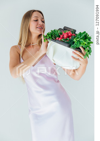 woman holding a bag of green vegetables for diet food and smiling woman holding a bag of green vegetables for diet food and smiling 127091994