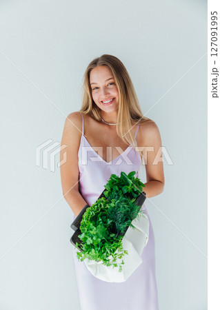 woman holding a bag of green vegetables for diet food and smiling woman holding a bag of green vegetables for diet food and smiling 127091995