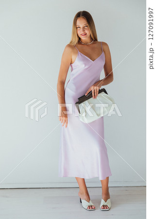 Portrait of beautiful fashionable blonde woman in purple summer silk dress smiling Portrait of beautiful fashionable blonde woman in purple summer silk dress smiling 127091997