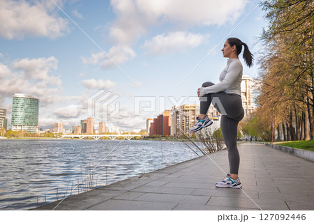 Sporty Woman Stretching Outdoors by the City Waterfront at Sunrise Sporty Woman Stretching Outdoors by the City Waterfront at Sunrise 127092446