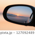 車の窓から見る夕日 127092489