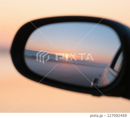 車の窓から見る夕日 127092489