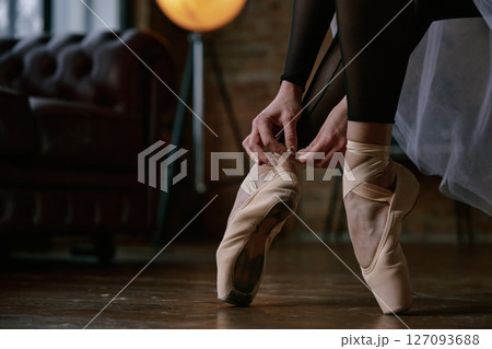 Crop shot of ballerina poses elegantly in a serene studio setting, capturing the essence of dance Crop shot of ballerina poses elegantly in a serene studio setting, capturing the essence of dance 127093688