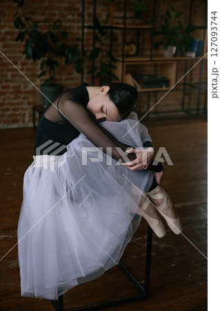 A graceful ballerina in a beautiful tutu practicing her moves in a serene studio setting 127093744