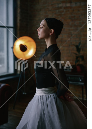 An elegant ballerina gracefully poised in a stunning modern studio setting illustrates artistry 127093877