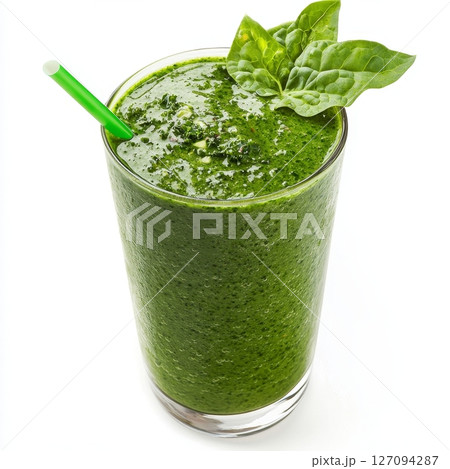 Refreshing green spinach smoothie with straw in glass 127094287