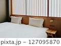 Minimalist Japanese hotel room with twin beds and soft white bedding, shoji screen. Modern ryokan interior  127095870