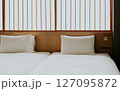 Minimalist Japanese hotel room with twin beds and soft white bedding, shoji screen. Modern ryokan interior  127095872