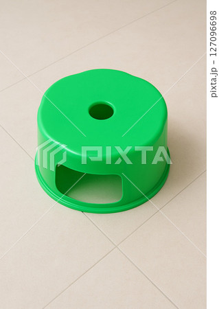 Green Plastic Stool on Clean Tile Floor Green Plastic Stool on Clean Tile Floor 127096698