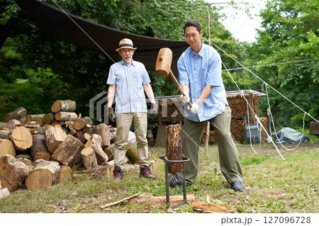 キャンプ場で薪割りをする男性　キャンプ　アウトドア　イメージ 127096728