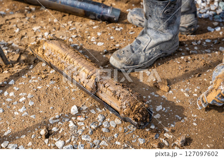 Fresh soil core sample placed on the ground after drilling. Subsurface material collected for geotechnical testing and laboratory analysis 127097602