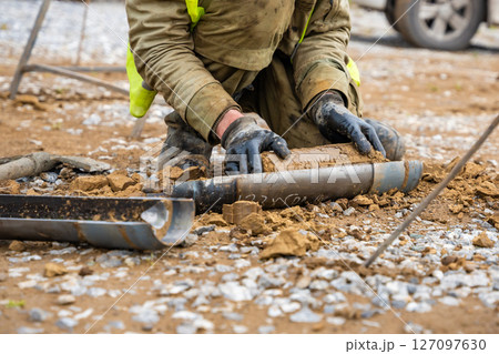 Man cutting and cleaning soil sample for laboratory analysis. Preparation of core material for geotechnical testing and scientific evaluatio Man cutting and cleaning soil sample for laboratory analysis. Preparation of core material for geotechnical testing and scientific evaluatio 127097630