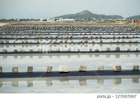 Sun drenched salt pan in Vietnam with mass sea salt evaporation. Agriculture rural field in Hon Knoi Sun drenched salt pan in Vietnam with mass sea salt evaporation. Agriculture rural field in Hon Knoi 127097667
