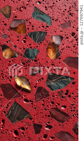 Semiprecious terrazzo surface with red base and gemstone fragments 127097941