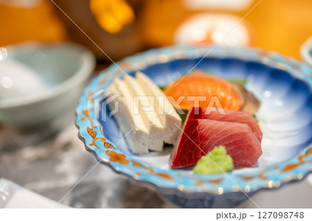 Japanese sashimi with slices of tuna, salmon, tofu and wasabi served in traditional porcelain plate 127098748
