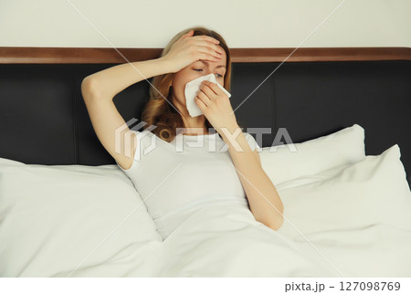 Sick exhausted young woman sneezing blow nose using tissue, unhealthy suffering girl feels unwell 127098769