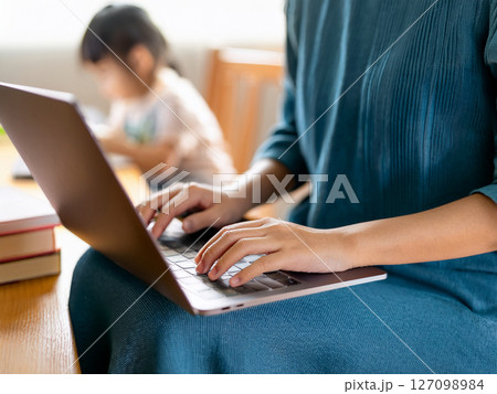 子供がいる部屋でノートパソコンを操作する女性 子供がいる部屋でノートパソコンを操作する女性 127098984