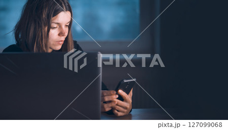 Girl works on a laptop in the evening. 127099068