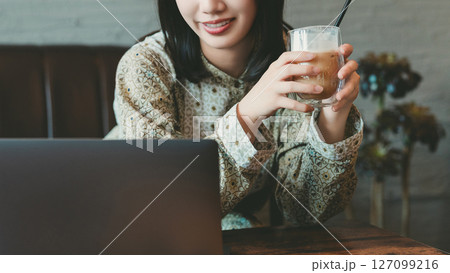 ソファに座ってパソコンを使う若い女性 ソファに座ってパソコンを使う若い女性 127099216