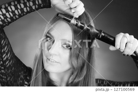 Happy woman curling her long brown hair 127100569